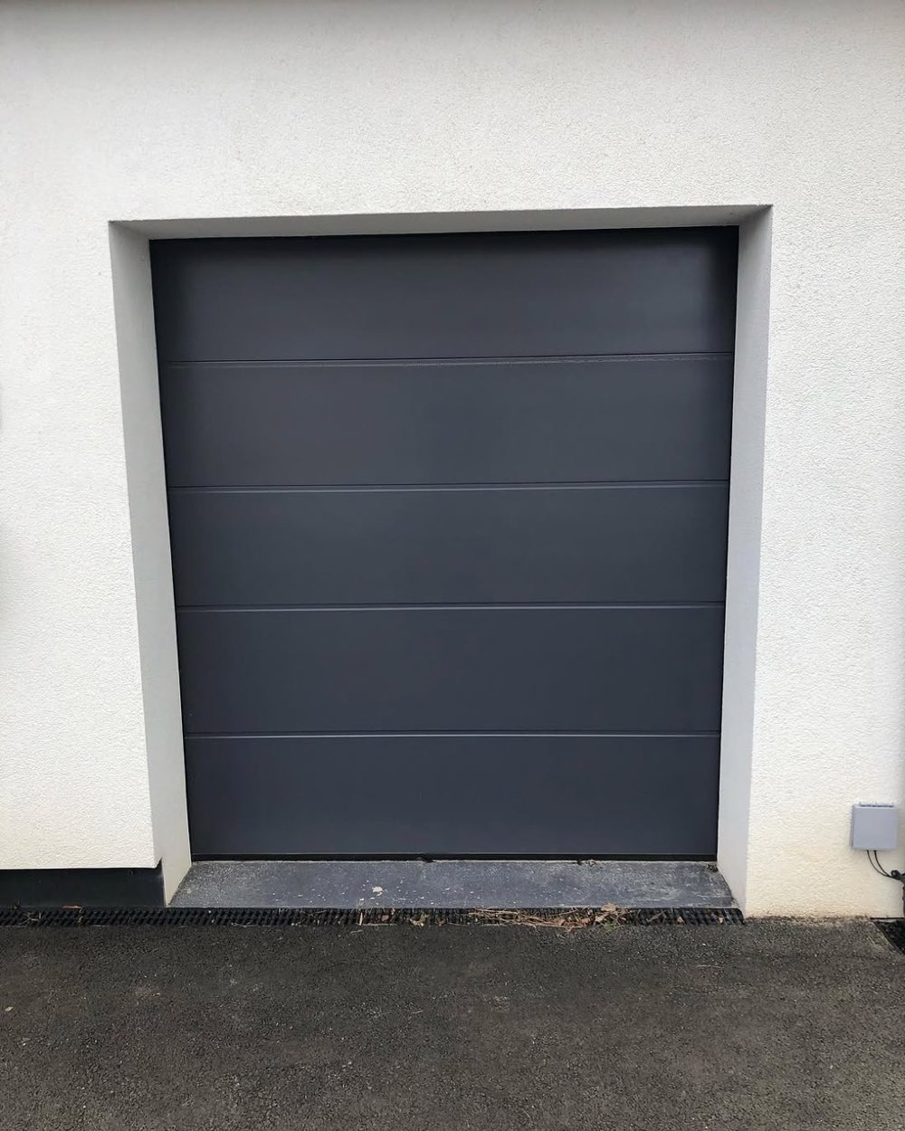 Anthracite grey sectional garage door installed by Arthur's Doors in Stockport