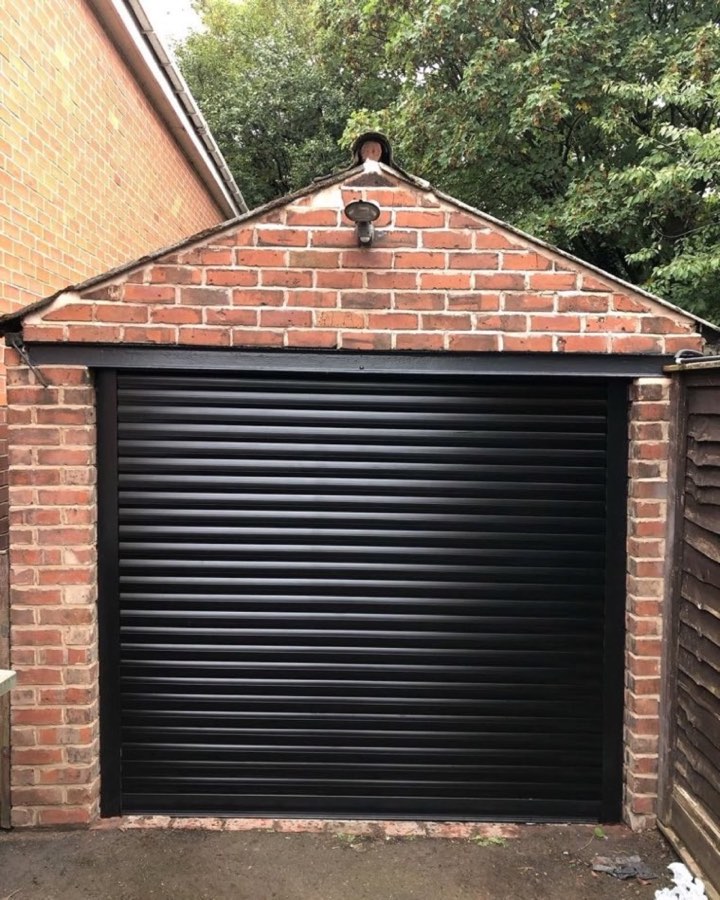 Black roller garage door fitted by Arthur's Doors on a traditional brick garage